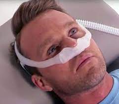 man laying down with Dreamwear Under the Nose Nasal Mask on